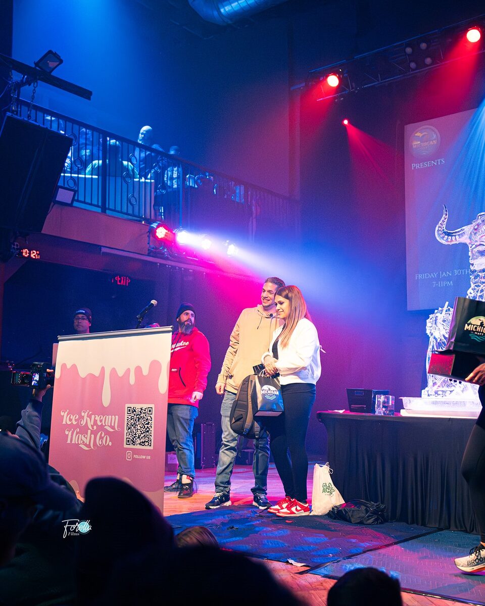 On stage beside the event banner